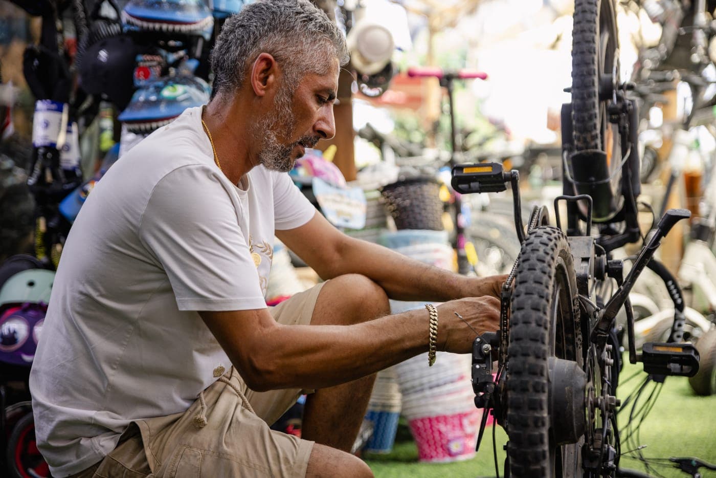 מכונאי מטפל בגלגל אחורי של אופניים בחנות